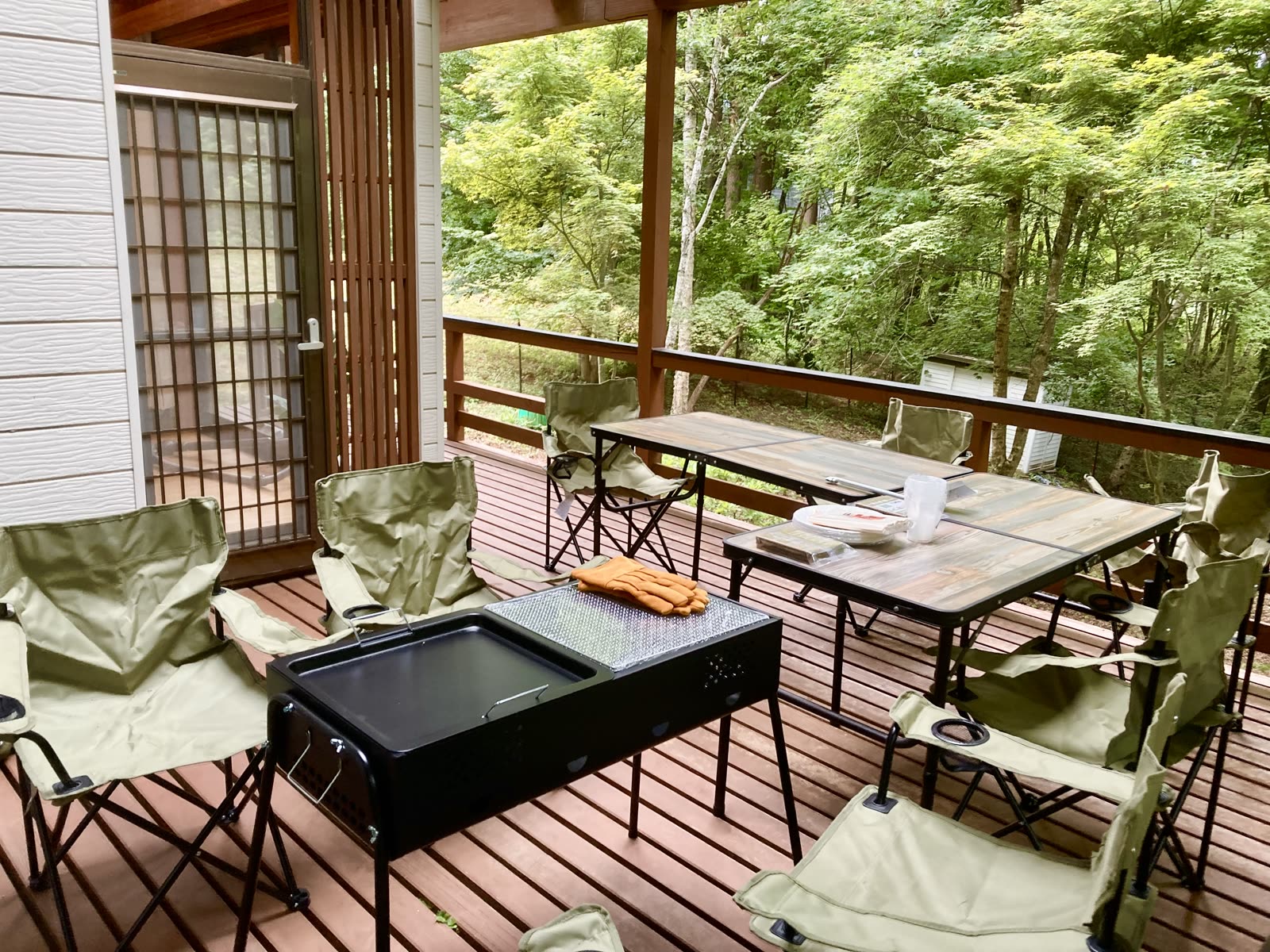 屋根付きウッドデッキに置いたBBQコンロとテーブル、チェア