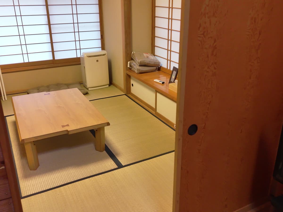 障子と襖のある6畳の和室。畳の中央に木の座卓を置いている